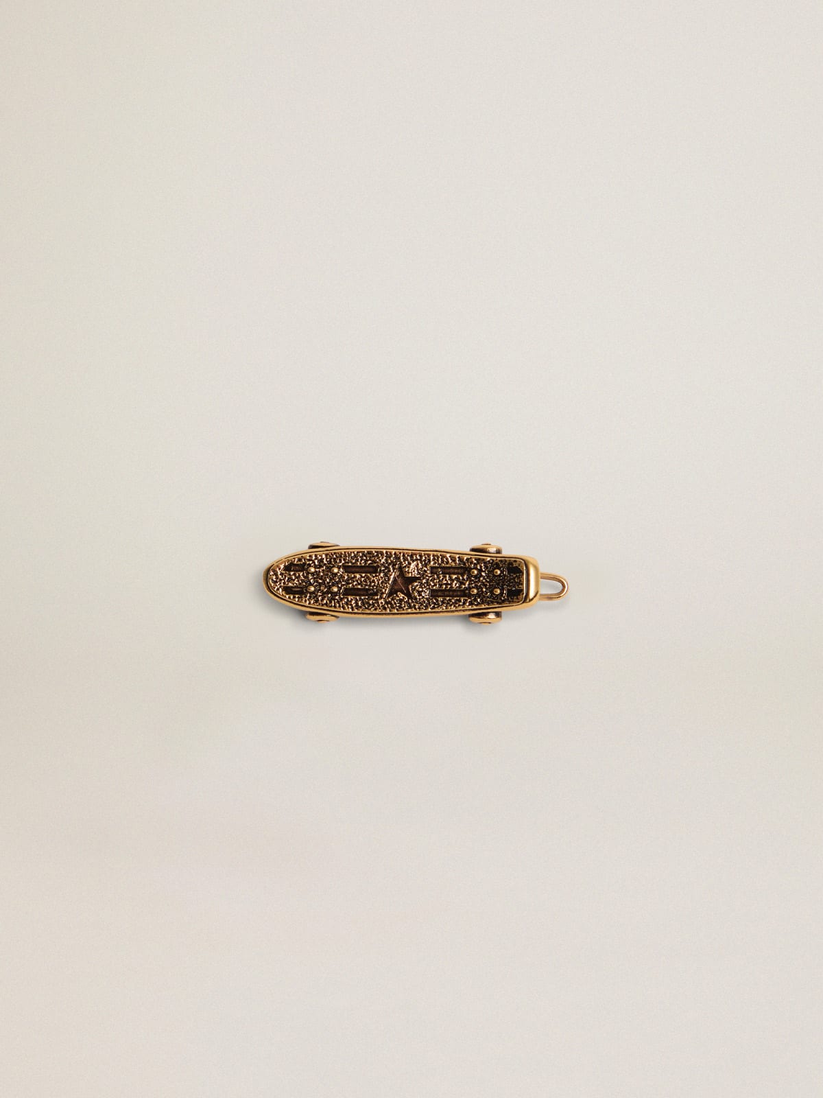 Timeless Jewelmates Collection lace accessory in old gold color in the shape of a skateboard