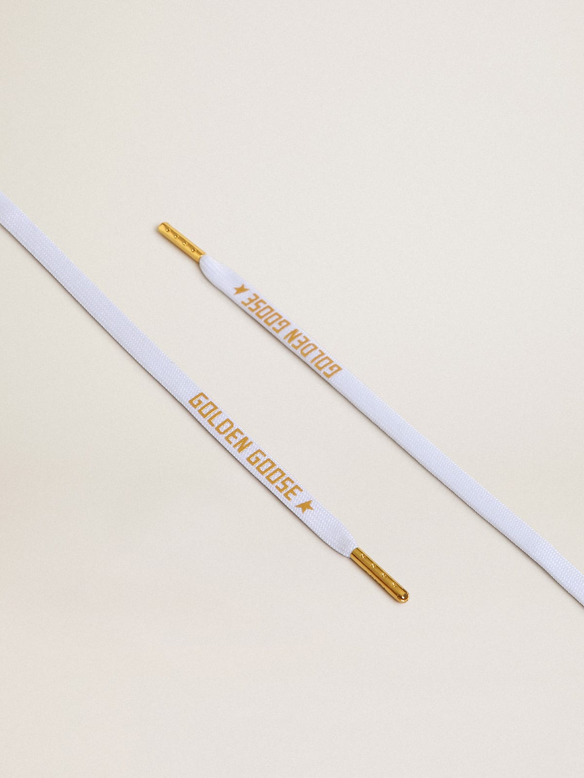 White cotton laces with contrasting gold-colored logo